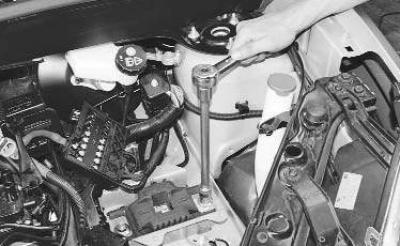 3. Отверните гайку шпильки крепления левой опоры подвески силового агрегата к кронштейну…