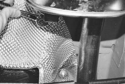 2. Отверните две гайки крепления термоэкранов в средней части кузова и снимите передний термоэкран.