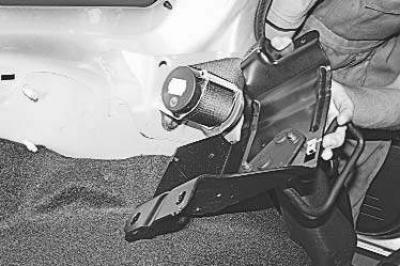 8. Снимите верхнюю и среднюю облицовки боковины (см. «Снятие и установка облицовок багажника»),…