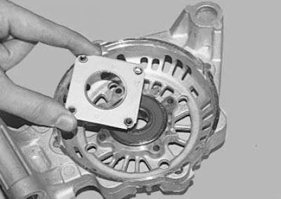 13. To replace the front rotor bearing, remove the four screws securing the pressure plate…