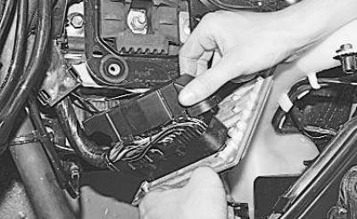 3. Подденьте отверткой фиксаторы крепления защитного кожуха колодки жгута проводов…