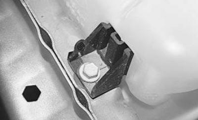 7. Odstráňte spodnú skrutku zaisťujúcu nádržku ostrekovača.