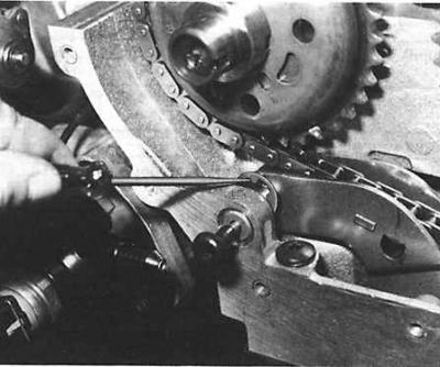 Снятие оси натяжного устройства приводной цепи системы газораспределения двигателя DOHC