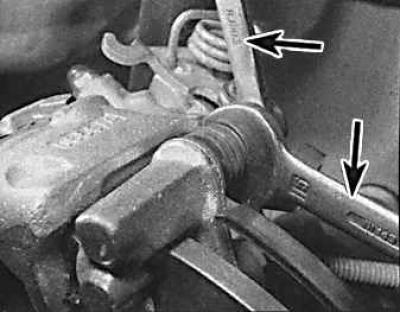 4. Disconnect the handbrake cable from the rear suspension arm.