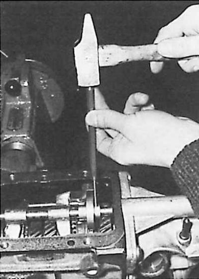 8. Извлечь штифт кулачка селектора задней передачи и вытянуть назад его ось.