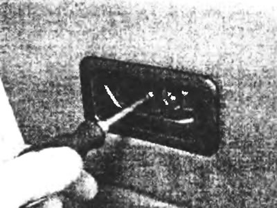 Рис. 9.4. Отверните крепежный винт и снимите облицовку ручки открывания замка.