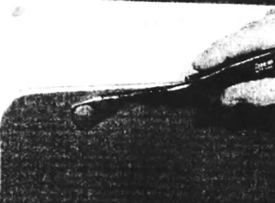 Рис. 9.11. Снятие пластмассового фиксатора инструментом с вилкой на конце.