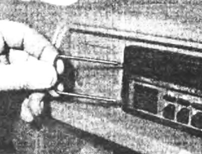 Рис. 23.6,б. Вставьте два инструмента для снятия в пазы с обеих сторон магнитолы...